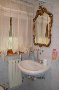 La salle de bains est pourvue d'un lavabo et d'un miroir. dans l'établissement A pochi passi dal mare, à Torre del Lago Puccini
