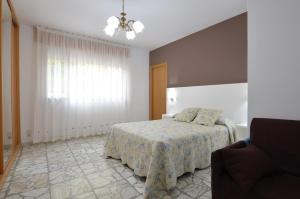 a bedroom with a bed and a window at Pension Asun Sanxenxo in Sanxenxo
