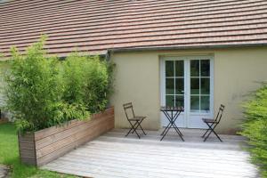 eine Veranda mit Stühlen, eine Tür und ein Haus in der Unterkunft Le loft du Clos d'Esquay in Esquay-sur-Seulles