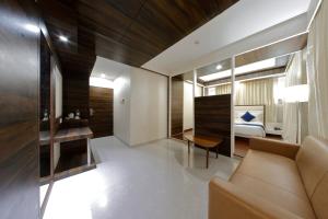 a living room with a couch and a bedroom at Hotel Silver Heights in Ahmedabad +19 photos