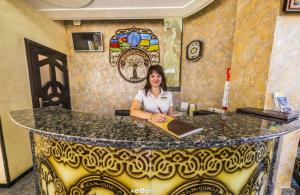 a woman sitting at a counter in a room at Khan-Chinar Hotel in Dnipro