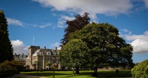 a large building with a tree in front of it at The Gleneagles Hotel in Auchterarder