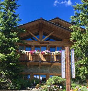 a building with a balcony with flowers on it at Chalet Bellavista in Livigno