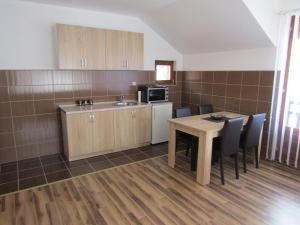 a kitchen with a table and chairs and a microwave at Apartment and rooms Konak in Višegrad