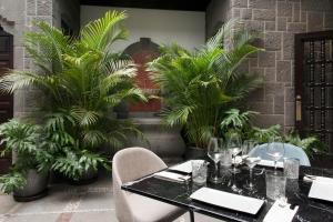 a dining room with a table and chairs and palm trees at Suites 1478 in Las Palmas de Gran Canaria