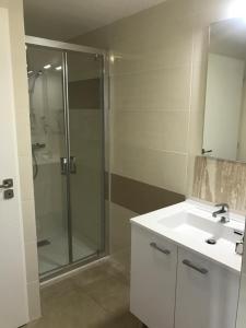 ein Bad mit einer Glasdusche und einem Waschbecken in der Unterkunft Naiades appartement in Le Lavandou