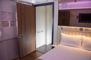 een kamer met een bed en een glazen schuifdeur bij Point A Hotel London Westminster in Londen