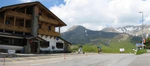 a building on a street with mountains in the background at B&B Passo del Cerreto in Cerreto Laghi