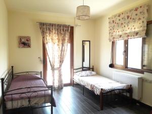 two beds in a room with a window at Ariadni's Maisonette in Yiofirákia