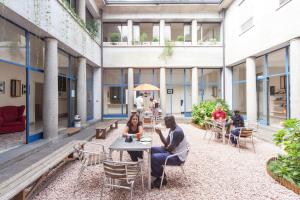a courtyard with people sitting at tables in a building at OstellOlinda in Milan