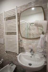 een badkamer met een wastafel en een spiegel bij 5 Terre Lodge in La Spezia