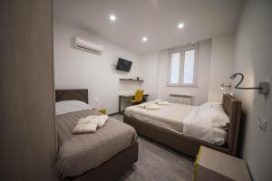 een slaapkamer met 2 bedden en een spiegel bij 5 Terre Lodge in La Spezia