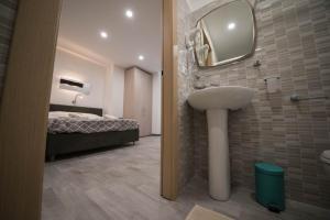 łazienka z umywalką, łóżkiem i lustrem w obiekcie 5 Terre Lodge w mieście La Spezia
