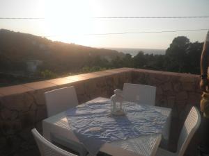 una mesa y sillas en un patio con vistas a la puesta de sol en Case Vacanze Zaffarano, en San Menaio