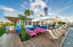 a deck with chairs and tables and an umbrella at Radisson Blu Hotel Batumi in Batumi