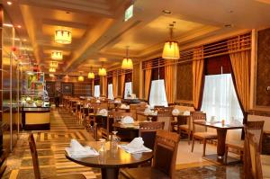 a restaurant with tables and chairs in a room at Ruve Al Madinah Hotel in Medina