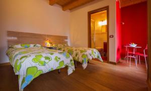 1 dormitorio con 2 camas y pared roja en B&B Al Gatto Nero, en Borgo
