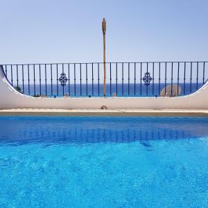 ein Pool mit einem Zaun und blauem Wasser in der Unterkunft Casa Sacy in Villajoyosa