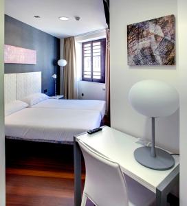 Habitación de hotel con cama, escritorio y silla en Hotel Lastres Miramar, en Lastres