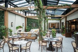 an outdoor patio with tables and chairs and plants at The Gleneagles Hotel in Auchterarder
