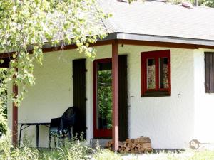 mały biały dom z czarnym krzesłem przed nim w obiekcie Ferien- & Freizeitpark Grafenhausen w mieście Grafenhausen