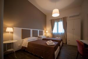 PartannaにあるLa Terrazza di Harmakhisのベッド2台と窓が備わるホテルルームです。
