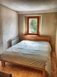 1 cama en un dormitorio con ventana en Predel House, en Log pod Mangartom