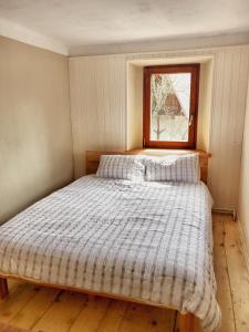uma cama num pequeno quarto com uma janela em Predel House em Log pod Mangartom