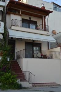 a white building with stairs and a balcony at To Spitaki in Neos Marmaras