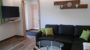 a living room with a black couch and a table at Haus Fliri in Curon Venosta