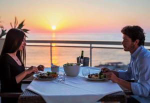 a man and woman sitting at a table with a plate of food at Lahoya Suites in Beirut