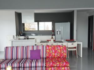 a living room with a couch and a kitchen at Red Grey Sea View Villa in Schinias