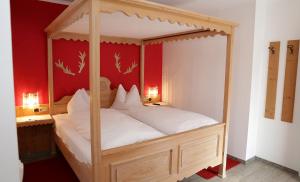 una camera con letto a baldacchino e lenzuola bianche di Berghotel Hois a Heiligenblut