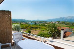 a balcony with a table and chairs and a view at House Baglija in Lumbarda