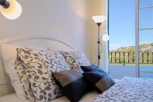 a bedroom with a bed with pillows and a window at Casa Conduto in Ponta do Sol
