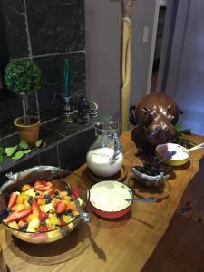 a wooden table with a bowl of fruit on it at Waterfront Lodge in Knysna