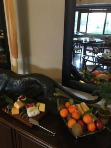a plate of cheese and fruit on a table at Waterfront Lodge in Knysna