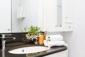 bagno con lavandino, asciugamani e specchio di Trave - Bayona a Pamplona
