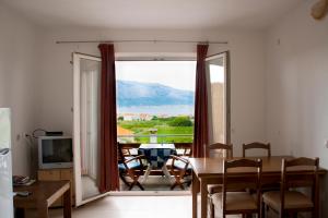 a dining room with a table and a large window at House Baglija in Lumbarda