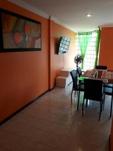 comedor con paredes de color naranja, mesa y sillas en Apartamento Perla del Caribe, en Santa Marta