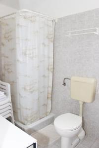a bathroom with a toilet and a shower curtain at Apartments Tonka in Primošten