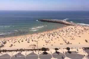 a group of people on a beach with the ocean at Hotel Apartamento Solverde in Espinho