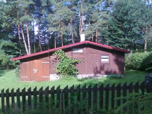 a small woodenshed in a yard with a fence at dom letni in Stare Jabłonki