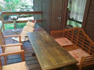 a wooden table and chairs sitting on a deck at dom letni in Stare Jabłonki