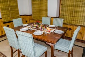 a dining room table with chairs and a table centerpiece at Pine Top Hotel Murree in Murree