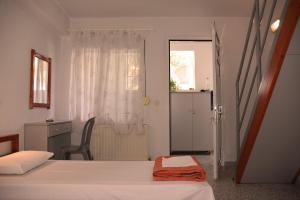 a bedroom with two beds and a chair and a window at Villa Stegiovana in Stavros +29 photos