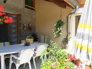 a blue table and chairs on a patio with flowers at Aux Cadollines in Romenay