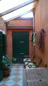 a patio with a green door and a table and chairs at The Merchant of Venice in Venice