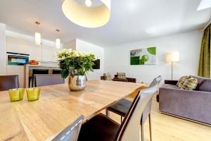 comedor y sala de estar con mesa de madera y sillas en Bergzauber Appartements, en Brand