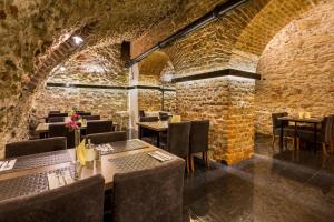 a restaurant with tables and chairs and a brick wall at Hotel Elektor Premium in Krakow